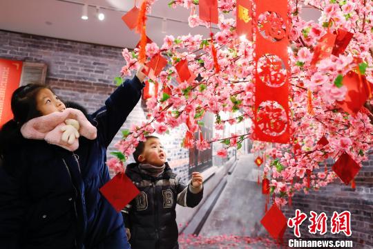 孩子們在許愿樹下寫下新年祝福。 殷立勤 攝