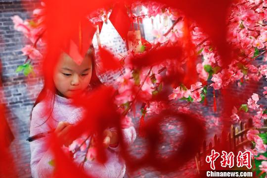 孩子在許愿樹下寫下新年祝福。 殷立勤 攝