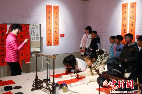 孩子在老師的指點下書寫春聯。 殷立勤 攝