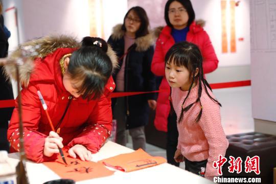 孩子在書寫春聯。 殷立勤 攝